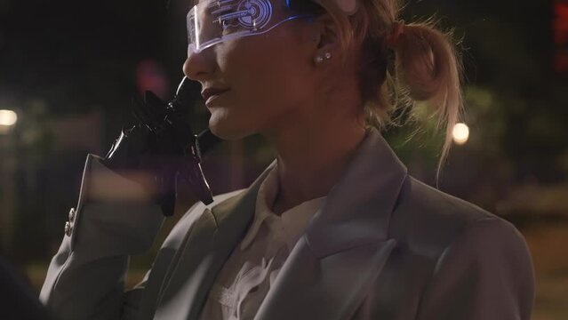 Cinematic footage of a business woman with cyborg bionic arm and augmented reality visor. Representation of the future that will include human being and tech parts - cyberpunk look video