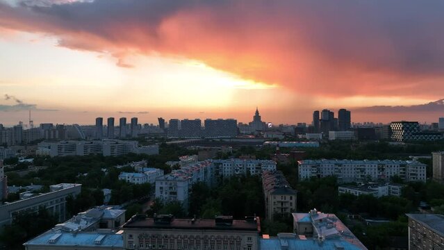 Epic aerial view of a beautiful sunset over city streets and rooftops. Beautiful buildings made of glass and concrete. The scarlet sky and the last rays of the sun over the metropolis.