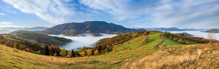 Morning foggy clouds in autumn mountain countryside.  Ukraine, Carpathian Mountains, Transcarpathia. Peaceful picturesque traveling, seasonal, nature and countryside beauty concept scene.