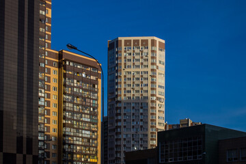 Fototapeta premium Facades of modern multi-storey buildings against a bright blue sky and a space for copying in the city Reutov, Moscow region, Russia