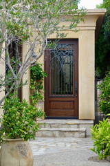 Fototapeta na wymiar Front entrance of a mediterranean Italian style villa with tall ornate front door
