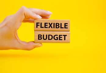 Flexible budget symbol. Concept words Flexible budget on wooden blocks. Beautiful yellow background. Businessman hand. Business and Flexible budget concept. Copy space.