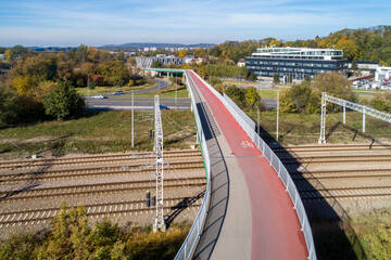 Footbridge with cycle path and pedestrian walkway over railway and city highway  in Krakow, Poland. Aerial view