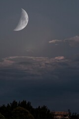 Beautiful large crescent moon in the cloudy sky © giadophoto