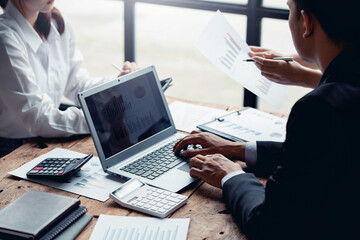 Close-up of businesspeople meeting group to discuss plans Think through graphs and charts. and calculate company performance, balance sheet, finance, income statement during the quarter.
