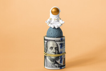 Global internet and investment. A rolled-up roll of dollars and a figure of an astronaut meditating...