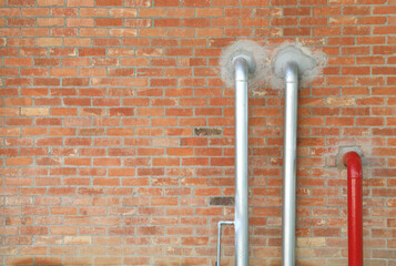Pipes installed on old brick wall
