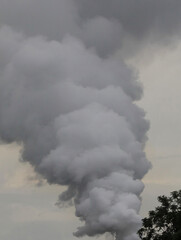 Dangerous smoke against cloudy sky. background.