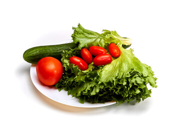 Fresh tomatoes, cucumber and lettuce on a white plate. Isolated.