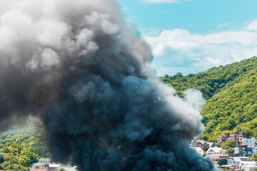 Fire in the village. Closeup of clouds of black smoke. The concept of an emergency, disaster and insurance