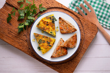 Spanish omelette with potatoes and spinach. Two pieces of bread with tomato. Typical tapas of Barcelona.