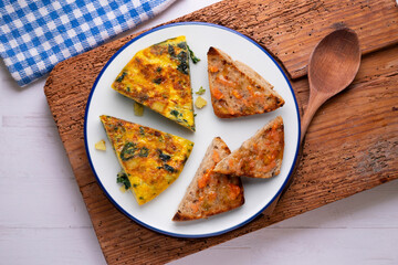 Spanish omelette with potatoes and spinach. Two pieces of bread with tomato. Typical tapas of Barcelona.