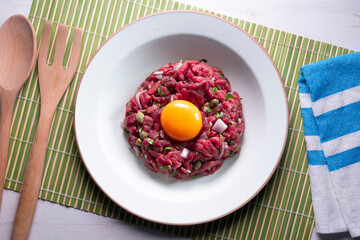 Traditional steak tartare with beef and egg yolk.