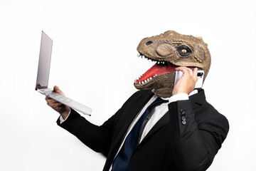 businessman with t rex head at a conference using his laptop and cellphone on white background © alejandro