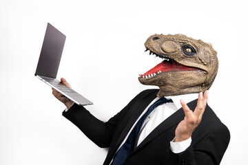 Businessman with T Rex mask using his laptop on white background