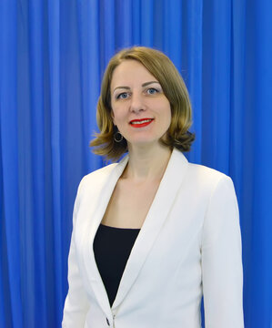 Portrait Of A Woman In A White Jacket Against A Blue Background
