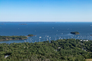 Fototapeta na wymiar Looking down at the coast of Maine, with sailboats and motor boats moored in the harbor