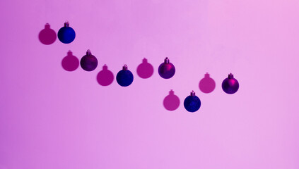 New Year's and Christmas decorative blue and purple balls on a pink background.