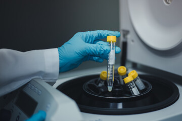 Scientist remove the test tubes of sample extraction from the centrifuge machine after centrifuging for DNA research into the next step. - obrazy, fototapety, plakaty