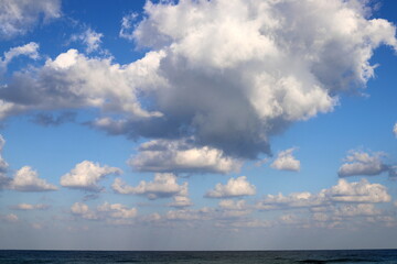 Naklejka na ściany i meble Large rain clouds in the sky over the sea.