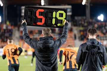 Man shows players substitution during football match.