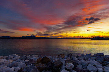 Krajobraz morski. Kamieniste wybrzeże i kolorowy zachód słońca, Evia