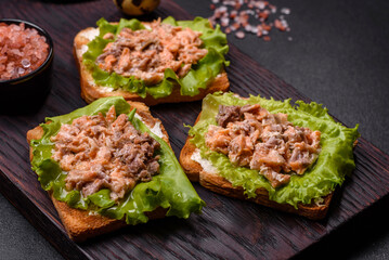 Delicious fresh sandwiches with toast, canned salmon, salad and quail eggs