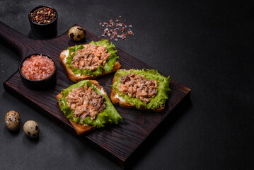 Delicious fresh sandwiches with toast, canned salmon, salad and quail eggs