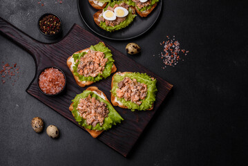 Delicious fresh sandwiches with toast, canned salmon, salad and quail eggs