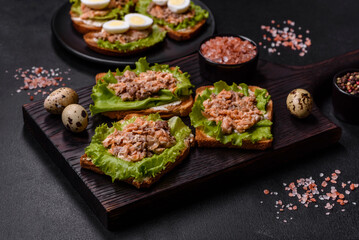 Delicious fresh sandwiches with toast, canned salmon, salad and quail eggs