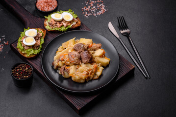 Delicious vegetable stew with beef, potatoes, carrots and cabbage in a black plate