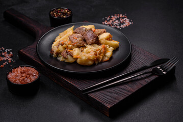 Delicious vegetable stew with beef, potatoes, carrots and cabbage in a black plate