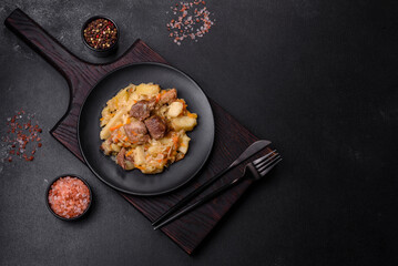Delicious vegetable stew with beef, potatoes, carrots and cabbage in a black plate