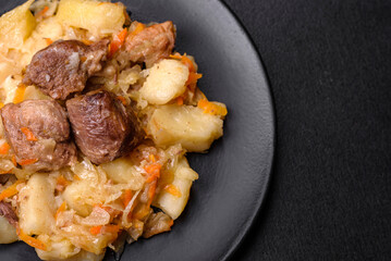 Delicious vegetable stew with beef, potatoes, carrots and cabbage in a black plate