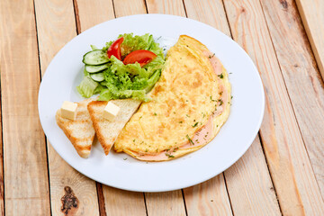 omelet with fresh vegetables and toasts