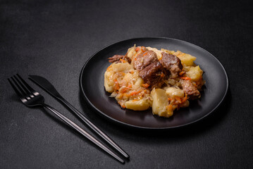 Delicious vegetable stew with beef, potatoes, carrots and cabbage in a black plate