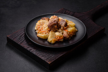 Delicious vegetable stew with beef, potatoes, carrots and cabbage in a black plate