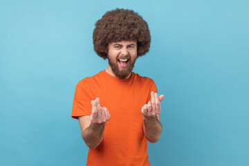 Give me cash. Portrait of man with Afro hairstyle in orange T-shirt showing money gesture, asking...
