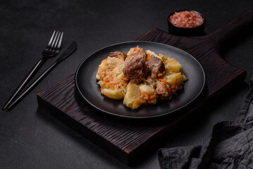 Delicious vegetable stew with beef, potatoes, carrots and cabbage in a black plate