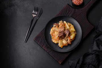 Delicious vegetable stew with beef, potatoes, carrots and cabbage in a black plate