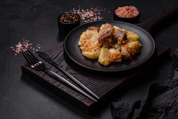 Delicious vegetable stew with beef, potatoes, carrots and cabbage in a black plate