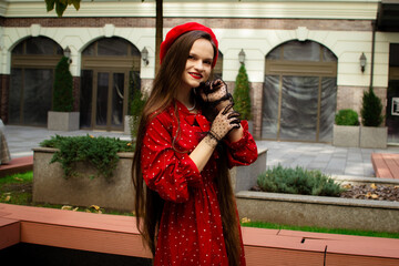 A girl in a red beret walks in the autumn city