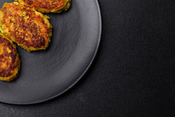 Diet vegetable cutlet from zucchini, carrot, herbs on a black plate
