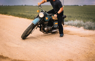Obraz premium motorcyclist drifting on a retro motorcycle on a sandy road, motocross training.