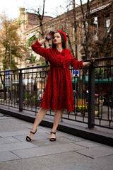 A girl in a red beret walks in the autumn city