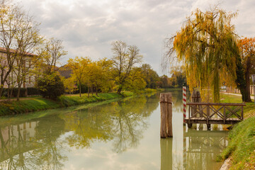 Beautiful autumn landscape. Canal with reflection of the trees. Concept of relaxation and meditation. Riviera del Brenta, Dolo, Italy.