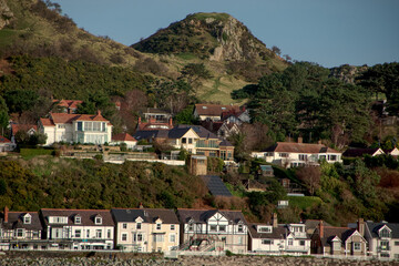 Naklejka premium houses under the mountain peaks Harbor town in Wales