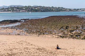 Woman sitting on the Beach of Saint Jean de Luz