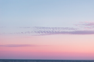 Naklejka na ściany i meble Purple-pink twilight sky and ocean on the horizon. Copy space. Background template. Time after sunset