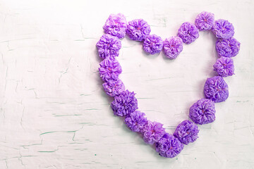 Heart of lilac flowers on a light background